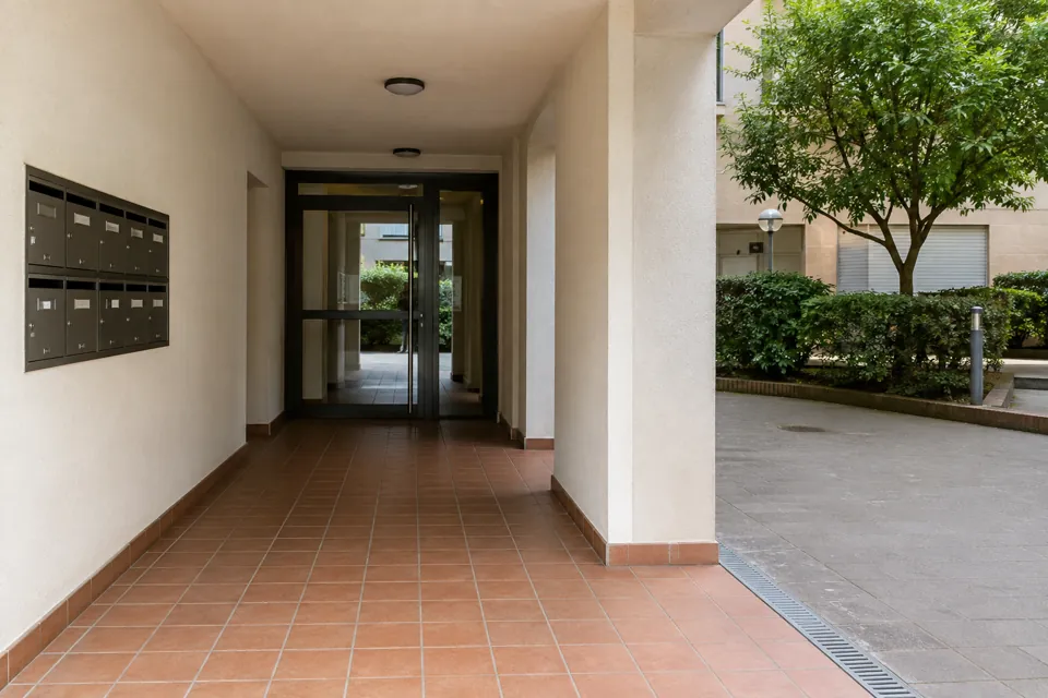 Acceso cubierto a una comunidad con pavimento cerámico y patio compartido